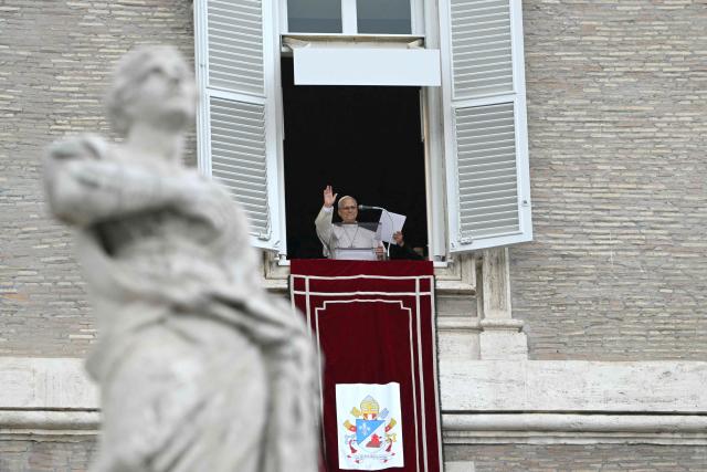 Pope Leo XIV waves from the window of the apostolic palace overlooking St. Peter's square during the Angelus prayer a day after his return to The Vatican following a surgery to remove a cancerous tumour in his right lung, on October 18, 2026. (Photo by Andreas SOLARO / AFP)