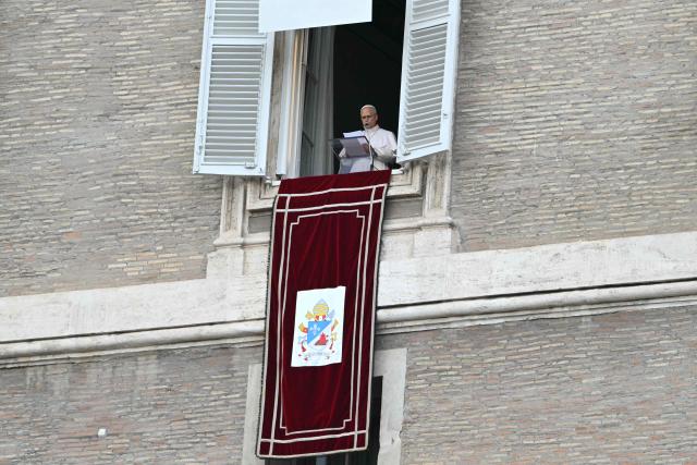 Pope Leo XIV addresses the crowd from the window of the apostolic palace overlooking St. Peter's square during the Angelus prayer a day after his return to The Vatican following a surgery to remove a cancerous tumour in his right lung, on October 18, 2026. (Photo by Andreas SOLARO / AFP)
