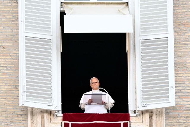 Pope Leo XIV addresses the crowd from the window of the apostolic palace overlooking St. Peter's square during the Angelus prayer a day after his return to The Vatican following a surgery to remove a cancerous tumour in his right lung, on October 18, 2026. (Photo by Tiziana FABI / AFP)