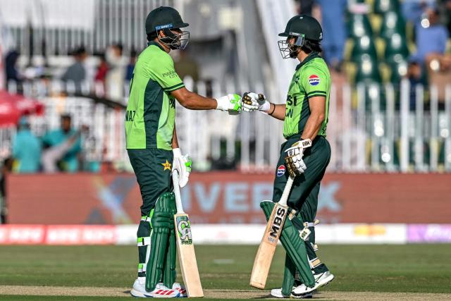 Pakistan's Hasan Nawaz (L) and Salman Agha bump their fists during the tri-series one-day international (ODI) cricket match between Pakistan and Sri Lanka at the Rawalpindi Cricket Stadium in Rawalpindi on October 18, 2026. (Photo by Aamir QURESHI / AFP)