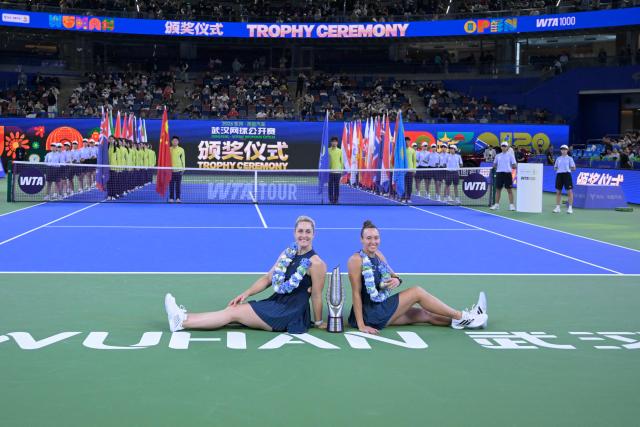 Brazil’s Luisa Stefani (R) and Canada’s Gabriela Dabrowski celebrate with the trophy after beating Czech Republic’s Katerina Siniakova and Australia's Storm Hunter in the women’s doubles final match at the Wuhan Open tennis tournament in Wuhan, China's Hubei province on October 18, 2026. (Photo by WANG Zhao / AFP)