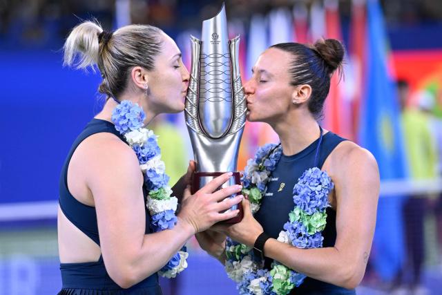 Brazil’s Luisa Stefani (R) and Canada’s Gabriela Dabrowski kiss the trophy after beating Czech Republic’s Katerina Siniakova and Australia's Storm Hunter in the women’s doubles final match at the Wuhan Open tennis tournament in Wuhan, China's Hubei province on October 18, 2026. (Photo by WANG Zhao / AFP)