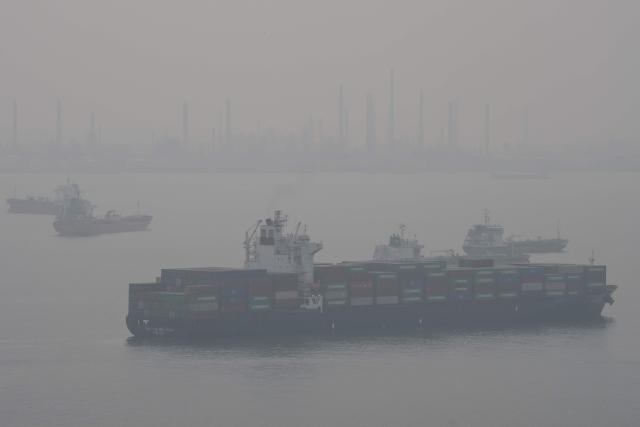 A cargo ship sails through the Singapore Strait in Singapore on October 18, 2026, as the country continues to be shrouded in haze caused by fires in Indonesia. (Photo by Yuichi YAMAZAKI / AFP)