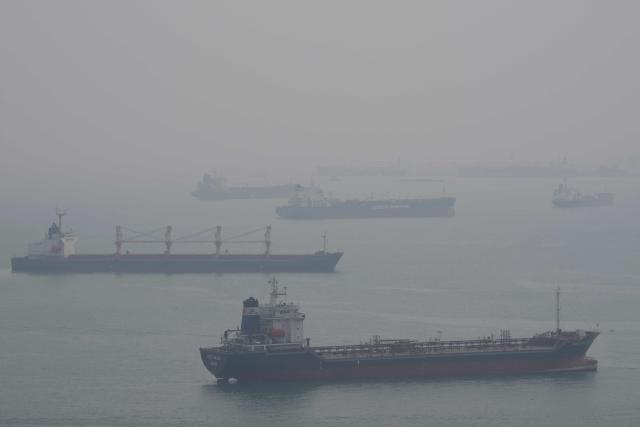 Ships are seen in the Singapore Strait from Sentosa Island in Singapore on October 18, 2026, as the country continues to be shrouded in haze caused by fires in Indonesia. (Photo by Yuichi YAMAZAKI / AFP)