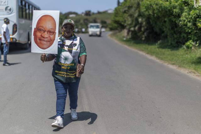 A supporter of the UmKhonto we Sizwe Party (MKP) holds a placard displaying the face of their President Jacob Zuma during an election campaign mini rally in Umgababa, south of Durban on October 18, 2026, ahead of the country’s upcoming municipal elections. (Photo by RAJESH JANTILAL / AFP)