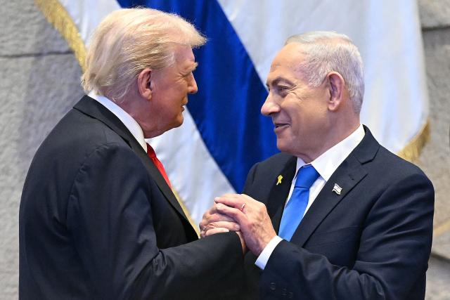 (FILES) US President Donald Trump (L) holds hands and speaks with Israeli Prime Minister Benjamin Netanyahu at the Israeli parliament, the Knesset, in Jerusalem on October 13, 2025. Trump on October 18, 2026, endorsed his ally Benjamin Netanyahu before Israel's close-fought parliamentary election on October 27 when the veteran prime minister will try to win a new mandate. "Bibi Netanyahu has been Strong, Brave, and Brilliant in the face of tremendous opposition, including that coming from even Israel, itself," Trump wrote on his Truth Social platform, using a common nickname for the Israeli leader. "This is the kind of Partner that the United States of America is demanding of Israel, a Country for which it has done so much. Please let this Letter serve to represent my Complete and Total Endorsement of Bibi Netanyahu in his upcoming Race for Re-Election as Prime Minister of Israel." (Photo by SAUL LOEB / POOL / AFP)