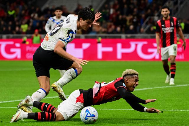 Atalanta's Slovenian defender #40 Relja Obric fights for the ball with AC Milan's English midfielder #20 Omari Hutchinson during the Italian Serie A football match between AC Milan and Atalanta at the San Siro Stadium in Milan on October 18, 2026. (Photo by Piero CRUCIATTI / AFP)