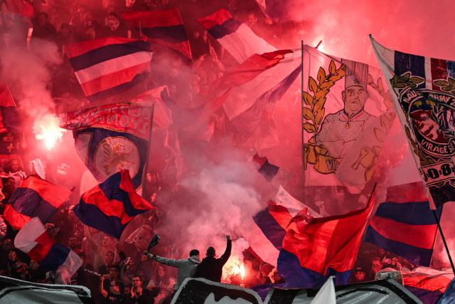 Lyon's supporters light up red smoke flares and wave flags ahead of the French L1 football match between Olympique Lyonnais (OL) and OGC Nice at the Groupama Stadium in Decines-Charpieu, central-eastern France, on October 18, 2026. (Photo by JEFF PACHOUD / AFP)