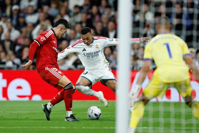 Real Madrid's French forward #10 Kylian Mbappe fights for the ball with Sevilla's Spanish defender #05 Andres Castrin during the Spanish league football match between Real Madrid CF and Sevilla FC at the Santiago Bernabeu stadium in Madrid on October 18, 2026. (Photo by Oscar DEL POZO / AFP)