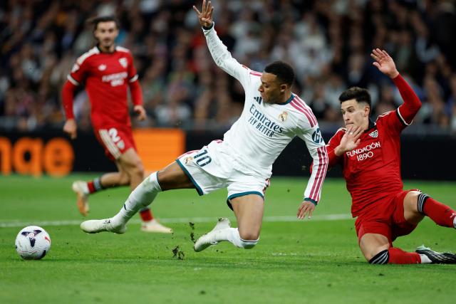 Real Madrid's French forward #10 Kylian Mbappe fights for the ball with Sevilla's Spanish defender #05 Andres Castrin during the Spanish league football match between Real Madrid CF and Sevilla FC at the Santiago Bernabeu stadium in Madrid on October 18, 2026. (Photo by Oscar DEL POZO / AFP)