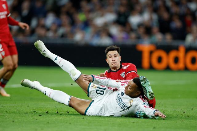 Real Madrid's French forward #10 Kylian Mbappe falls as he fights for the ball with Sevilla's Spanish defender #05 Andres Castrin during the Spanish league football match between Real Madrid CF and Sevilla FC at the Santiago Bernabeu stadium in Madrid on October 18, 2026. (Photo by Oscar DEL POZO / AFP)