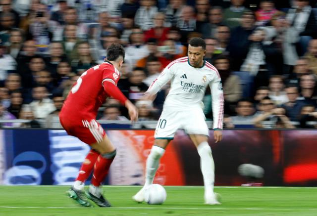 Real Madrid's French forward #10 Kylian Mbappe fights for the ball with Sevilla's Spanish defender #05 Andres Castrin during the Spanish league football match between Real Madrid CF and Sevilla FC at the Santiago Bernabeu stadium in Madrid on October 18, 2026. (Photo by Oscar DEL POZO / AFP)