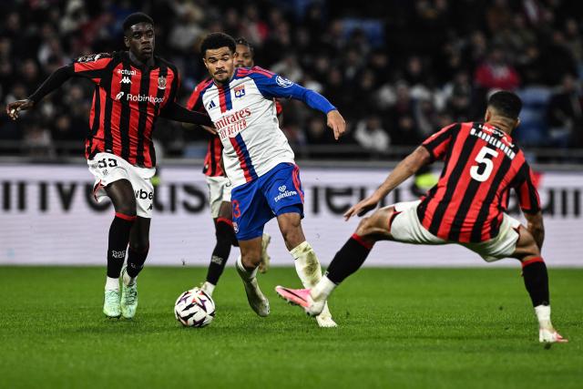 Lyon's Swiss defender #13 Zachary Athekame (C) fights for the ball with Nice's French midfielder #35 Xavier Mandza (L) during the French L1 football match between Olympique Lyonnais (OL) and OGC Nice at the Groupama Stadium in Decines-Charpieu, central-eastern France, on October 18, 2026. (Photo by JEFF PACHOUD / AFP)