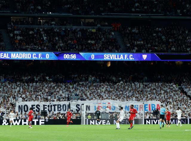 Real Madrid's supporters hold a banner reading 'This is not football, this is Tebas and Negreira', refering to a corruption case of alleged bribery payments to former refereeing head, during the Spanish league football match between Real Madrid CF and Sevilla FC at the Santiago Bernabeu stadium in Madrid on October 18, 2026. (Photo by Oscar DEL POZO / AFP)