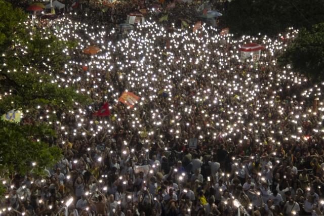 Aerial view shows people attending the "Ato Musical pela Democracia" (Musical Act for Democracy), a concert held in defense of democracy, at Copacabana Beach in Rio de Janeiro, Brazil, on October 18, 2026, one week before the presidential runoff. (Photo by Pablo PORCIUNCULA / AFP)