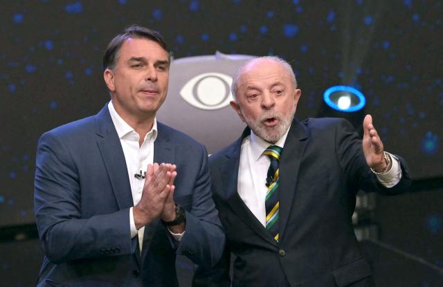 Brazil's President and presidential candidate Luiz Inacio Lula da Silva (R) and Brazil's right-wing presidential candidate Flavio Bolsonaro speak during a debate ahead of the presidential election runoff in Sao Paulo, Brazil, on October 18, 2026. (Photo by NELSON ALMEIDA / AFP)