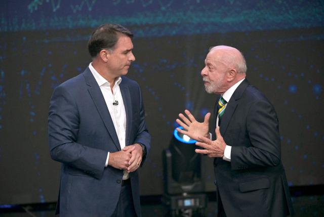 Brazil's President and presidential candidate Luiz Inacio Lula da Silva (R) and Brazil's right-wing presidential candidate Flavio Bolsonaro speak during a debate ahead of the presidential election runoff in Sao Paulo, Brazil, on October 18, 2026. (Photo by NELSON ALMEIDA / AFP)