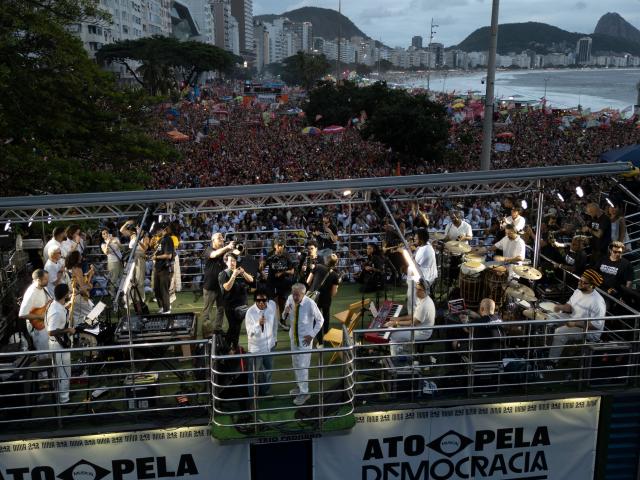 Brazilian singers Djavan (L) and Caetano Veloso perform during the "Ato Musical pela Democracia" (Musical Act for Democracy), a concert held in defense of democracy, at Copacabana Beach in Rio de Janeiro, Brazil, on October 18, 2026, one week before the presidential runoff. (Photo by Pablo PORCIUNCULA / AFP)
