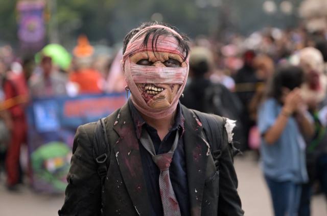 A reveller attends the annual Zombie Walk in Mexico City on October 18, 2026. (Photo by Alfredo ESTRELLA / AFP)