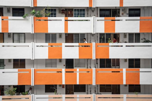 A student walks along the corridor of a public housing apartment block in Singapore on October 19, 2026, as the country continues to be shrouded in haze caused by fires in Indonesia. (Photo by Yuichi YAMAZAKI / AFP)