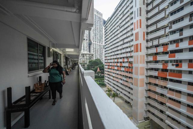 A woman walks along the corridor of a public housing apartment block in Singapore on October 19, 2026, as the country continues to be shrouded in haze caused by fires in Indonesia. (Photo by Yuichi YAMAZAKI / AFP)