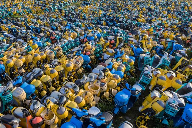 A large number of electric scooters, abandoned or unused, are piled up in an open area in Yuecheng District, Shaoxing, in eastern China's Zhejiang province, on October 17, 2026. (Photo by CN-STR / AFP) / China OUT
