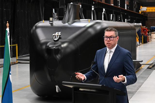 Australia’s Minister for Defence Industry, Pat Conroy, speaks to the media in front of the autonomous undersea vehicle Ghost Shark at an Anduril facility in Sydney on October 19, 2026, during the unveiling of three new capabilities for the company’s autonomous systems under AUKUS Pillar II. (Photo by Saeed KHAN / AFP)
