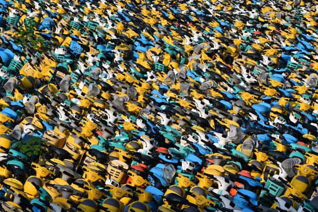A large number of electric scooters, abandoned or unused, are piled up in an open area in Yuecheng District, Shaoxing, in eastern China's Zhejiang province, on October 17, 2026. (Photo by CN-STR / AFP) / China OUT