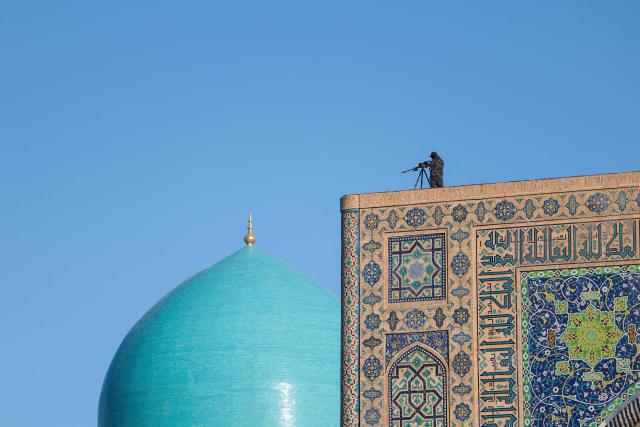 A sniper takes position to secure the area ahead of a visit by US Secretary of State Marco Rubio to Registan Square in Samarkand, Uzbekistan, on October 19, 2026. Rubio launches into talks on October 19 with key Central Asian states before heading to India on a tour to a region with vast natural resources and China as a key competitor. (Photo by Kylie Cooper / POOL / AFP)