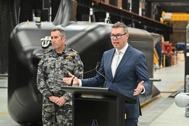 Australia’s Minister for Defence Industry Pat Conroy (R) speaks to the media alongside Royal Australian Navy Chief Vice Admiral Matthew Buckley in front of the Ghost Shark autonomous undersea vehicles at an Anduril facility in Sydney on October 19, 2026, during the unveiling of three new autonomous systems capabilities under AUKUS Pillar II. (Photo by Saeed KHAN / AFP)