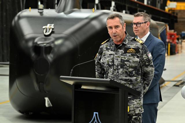 Royal Australian Navy Chief Vice Admiral Matthew Buckley speaks to the media alongside Australia’s Minister for Defence Industry Pat Conroy in front of the Ghost Shark autonomous undersea vehicles at an Anduril facility in Sydney on October 19, 2026, during the unveiling of three new autonomous systems capabilities under AUKUS Pillar II. (Photo by Saeed KHAN / AFP)
