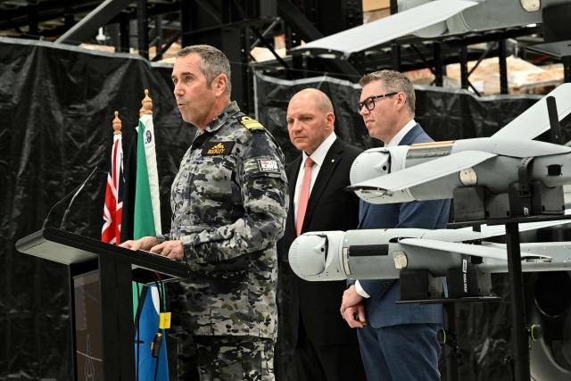 Royal Australian Navy Chief of Navy Vice Admiral Matthew Buckley (L) speaks to the media alongside Australia’s Minister for Defence Industry Pat Conroy (R), and Anduril Australia & Asia Pacific CEO and Executive Chairman David Goodrich at an Anduril facility in Sydney on October 19, 2026, during the unveiling of three new autonomous systems capabilities under AUKUS Pillar II. (Photo by Saeed KHAN / AFP)