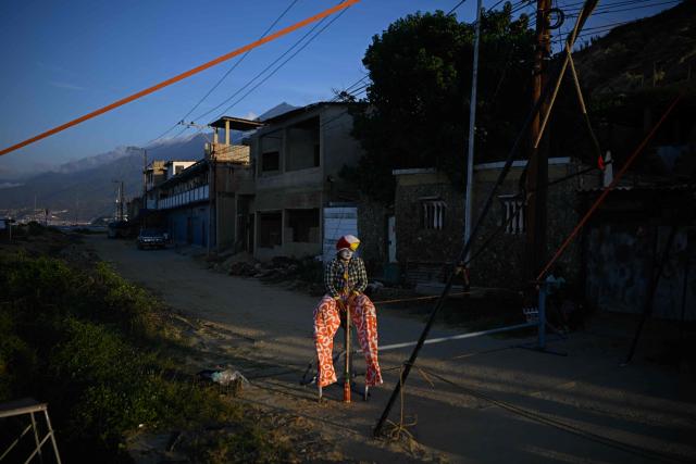 A member of the TET Center for Artistic Creation rest during the 6th Social Festival of Performing Arts in Playa Verde, Catia La Mar, La Guaira state, Venezuela, on October 18, 2026. The TET Center for Artistic Creation perform for survivors of two June 24, 2026, devastating earthquakes which killed more than 6,500 people. (Photo by Federico PARRA / AFP)