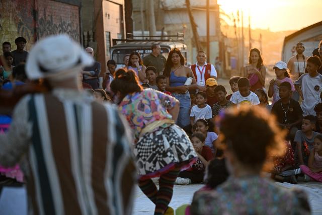People watch a performance by members of the TET Center for Artistic Creation during the 6th Social Festival of Performing Arts in Playa Verde, Catia La Mar, La Guaira state, Venezuela, on October 18, 2026. The TET Center for Artistic Creation perform for survivors of two June 24, 2026, devastating earthquakes which killed more than 6,500 people. (Photo by Federico PARRA / AFP)