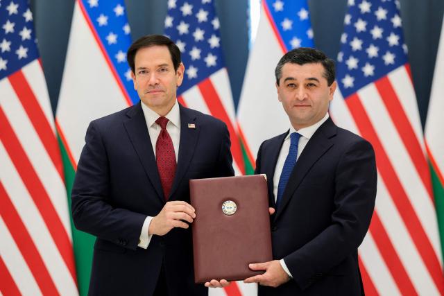 US Secretary of State Marco Rubio (L) and Uzbekistan's Foreign Minister Bakhtiyor Saidov pose for a picture holding the Artemis Accords during a signing ceremony at the Congress Center in Samarkand, Uzbekistan, on October 19, 2026. (Photo by Kylie Cooper / POOL / AFP)