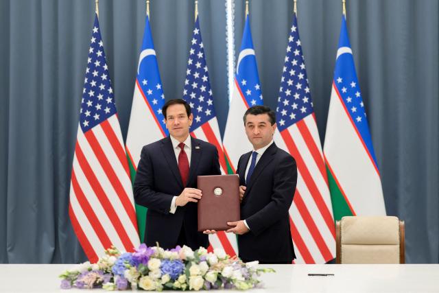 US Secretary of State Marco Rubio (L) and Uzbekistan's Foreign Minister Bakhtiyor Saidov pose for a picture holding the Artemis Accords during a signing ceremony at the Congress Center in Samarkand, Uzbekistan, on October 19, 2026. (Photo by Kylie Cooper / POOL / AFP)