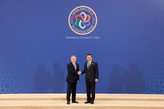 Uzbekistan's Foreign Minister Bakhtiyor Saidov shakes hands with Kyrgyzstan's Foreign Minister Jeenbek Kulubayev at the Congress Center in Samarkand, Uzbekistan, on October 19, 2026. (Photo by Kylie Cooper / POOL / AFP)