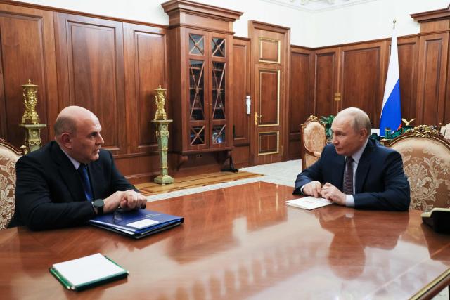 In this pool photograph distributed by the Russian state agency Sputnik, Russia's President Vladimir Putin meets with Prime Minister Mikhail Mishustin in Moscow on October 19, 2026. (Photo by Mikhail METZEL / POOL / AFP)