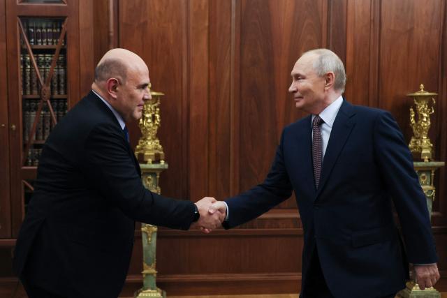 In this pool photograph distributed by the Russian state agency Sputnik, Russia's President Vladimir Putin meets with Prime Minister Mikhail Mishustin in Moscow on October 19, 2026. (Photo by Mikhail METZEL / POOL / AFP)