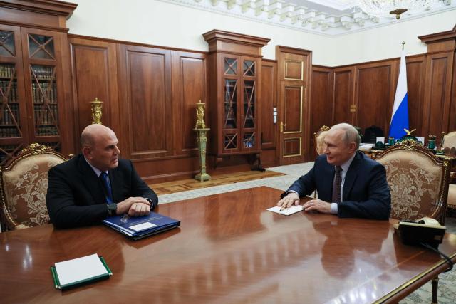 In this pool photograph distributed by the Russian state agency Sputnik, Russia's President Vladimir Putin meets with Prime Minister Mikhail Mishustin in Moscow on October 19, 2026. (Photo by Mikhail METZEL / POOL / AFP)