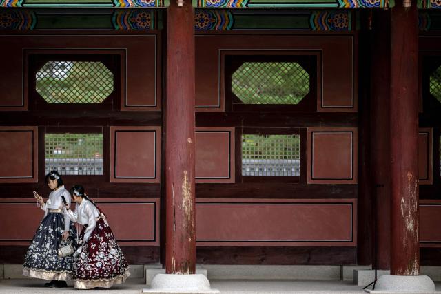 Tourists in traditional Hanbok outfits visit Gyeongbokgung Palace in Seoul on October 19, 2026. (Photo by Philip FONG / AFP)