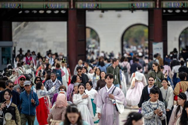 Tourists in traditional Hanbok outfits visit Gyeongbokgung Palace in Seoul on October 19, 2026. (Photo by Philip FONG / AFP)