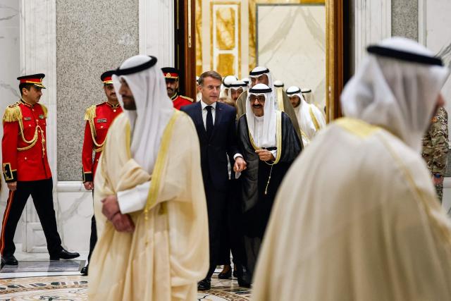 French President Emmanuel Macron (C-L) walks with the Emir of Kuwait Sheikh Meshal Al-Ahmad Al-Jaber Al-Sabah at Bayan Palace in Kuwait City, in Kuwait City on October 19, 2026. The French president arrived in Kuwait on October 19, beginning a tour of four Gulf countries, Kuwait, UAE, Bahrain and Qatar. (Photo by Benoit Tessier / POOL / AFP)