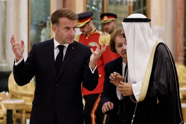 French President Emmanuel Macron (C-L) walks with the Emir of Kuwait Sheikh Meshal Al-Ahmad Al-Jaber Al-Sabah at Bayan Palace in Kuwait City, in Kuwait City on October 19, 2026. The French president arrived in Kuwait on October 19, beginning a tour of four Gulf countries, Kuwait, UAE, Bahrain and Qatar. (Photo by Benoit Tessier / POOL / AFP)