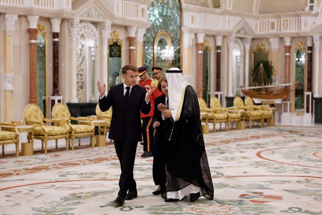 French President Emmanuel Macron (C-L) walks with the Emir of Kuwait Sheikh Meshal Al-Ahmad Al-Jaber Al-Sabah at Bayan Palace in Kuwait City, in Kuwait City on October 19, 2026. The French president arrived in Kuwait on October 19, beginning a tour of four Gulf countries, Kuwait, UAE, Bahrain and Qatar. (Photo by Benoit Tessier / POOL / AFP)