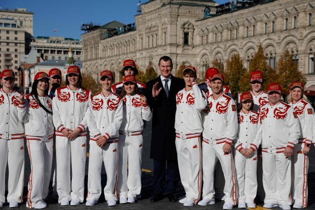 Russian Sports Minister Mikhail Degtyarev, Russian athletes, who will participate in the Dakar 2026 Youth Olympic Games, and sports officials pose on Red Square after getting official outfits at the Bosco equipment center in Moscow on October 19, 2026. (Photo by TATYANA MAKEYEVA / AFP)