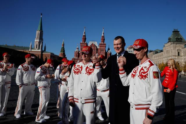 Russian Sports Minister Mikhail Degtyarev, Russian athletes, who will participate in the Dakar 2026 Youth Olympic Games, and sports officials interact on Red Square after getting official outfits at the Bosco equipment center in Moscow on October 19, 2026. (Photo by TATYANA MAKEYEVA / AFP)