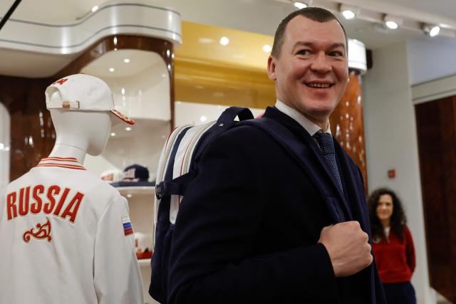 Russian Sports Minister Mikhail Degtyarev tries a backpack as Russian athletes, who will participate in the Dakar 2026 Youth Olympic Games, and sports officials get official outfits at the Bosco equipment center in Moscow on October 19, 2026. (Photo by TATYANA MAKEYEVA / AFP)