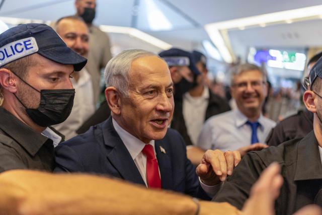Israeli Prime Minister Benjamin Netanyahu stands amid security personnel as he meets with voters at a mall in Ramle on October 19, 2026. Israel heads to the polls on October 27 in its first election since the October 7, 2023 Hamas-led attack, in what is seen as a referendum on the prime minister. (Photo by ilia YEFIMOVICH / AFP)