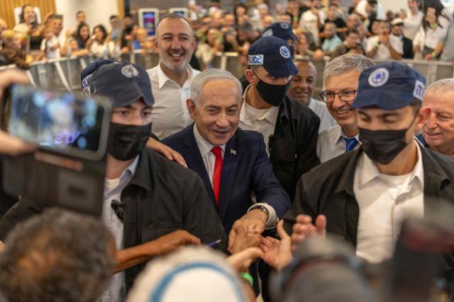 Israeli Prime Minister Benjamin Netanyahu stands amid security personnel as he meets with voters at a mall in Ramle on October 19, 2026. Israel heads to the polls on October 27 in its first election since the October 7, 2023 Hamas-led attack, in what is seen as a referendum on the prime minister. (Photo by ilia YEFIMOVICH / AFP)